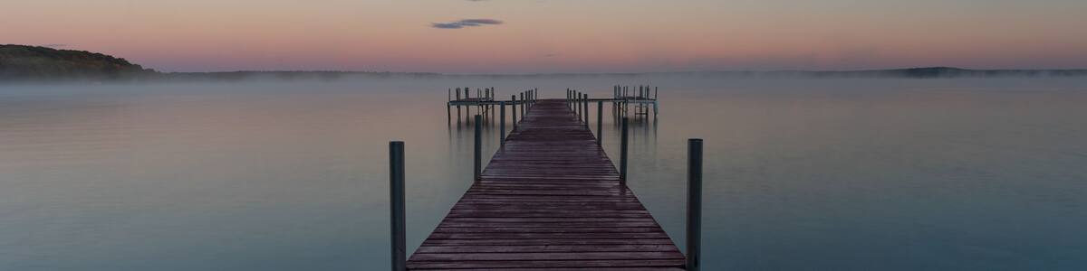 Dock on Mullett Lake in Indian River Michigan with pastel skies overhead