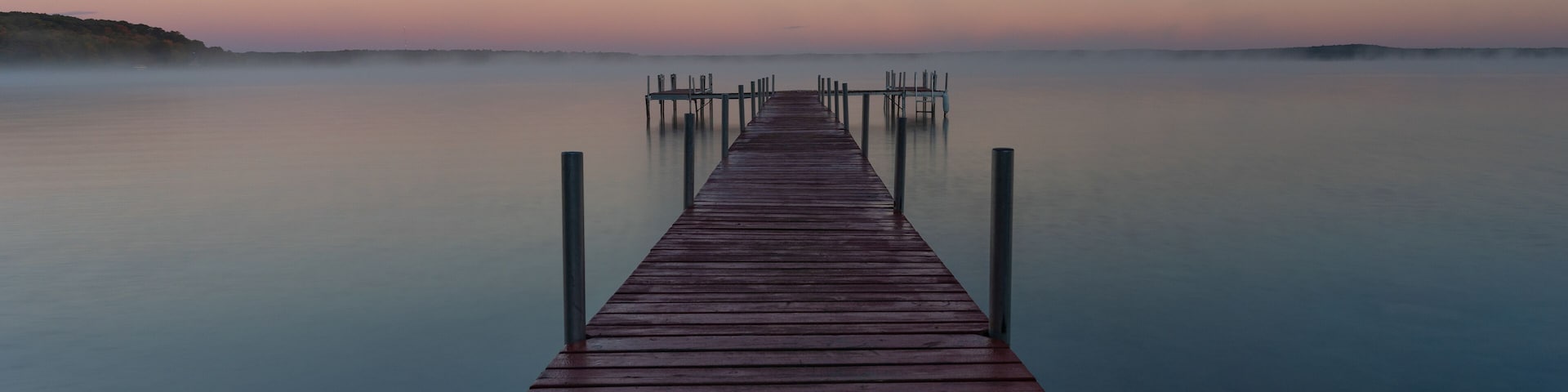 Dock on Mullett Lake in Indian River Michigan with pastel skies overhead