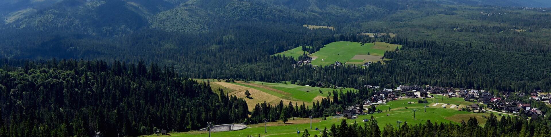 Majestic mountains peaks of High Tatra moutnains. High Tatras and Male Ciche ski resort seen from a metal observation tower with a modern glass terrace offering a stunning panorama at Poronin, Poland