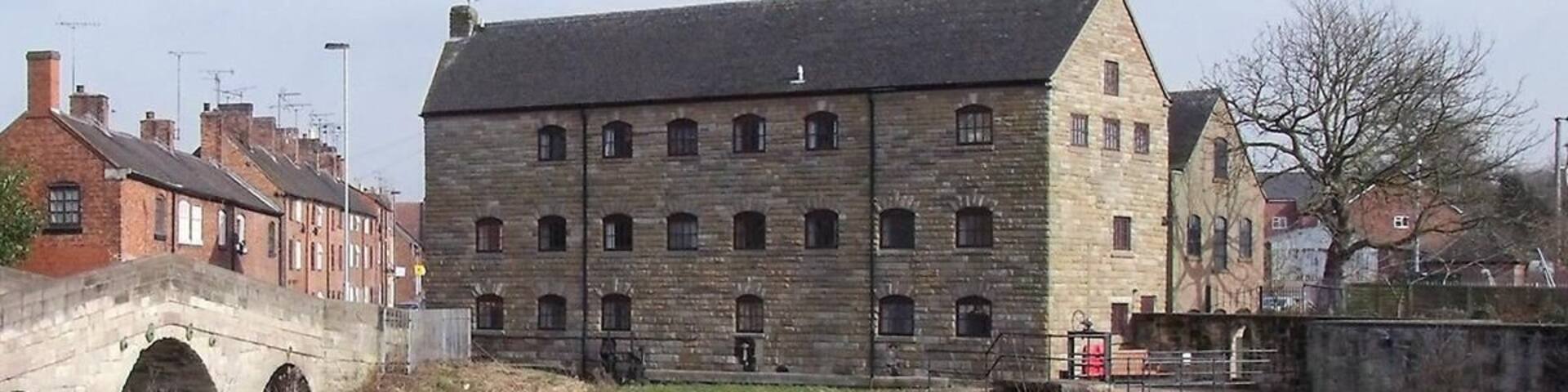 Rocester Corn Mill There has been a corn mill on the Churnet at Rocester for centuries. This mill was originally powered by an undershot wheel, on the right-hand side where the sluices now are. The wheel has now been replaced by a 58kW turbine for generating electricity and the building is now the offices of JCB Finance.