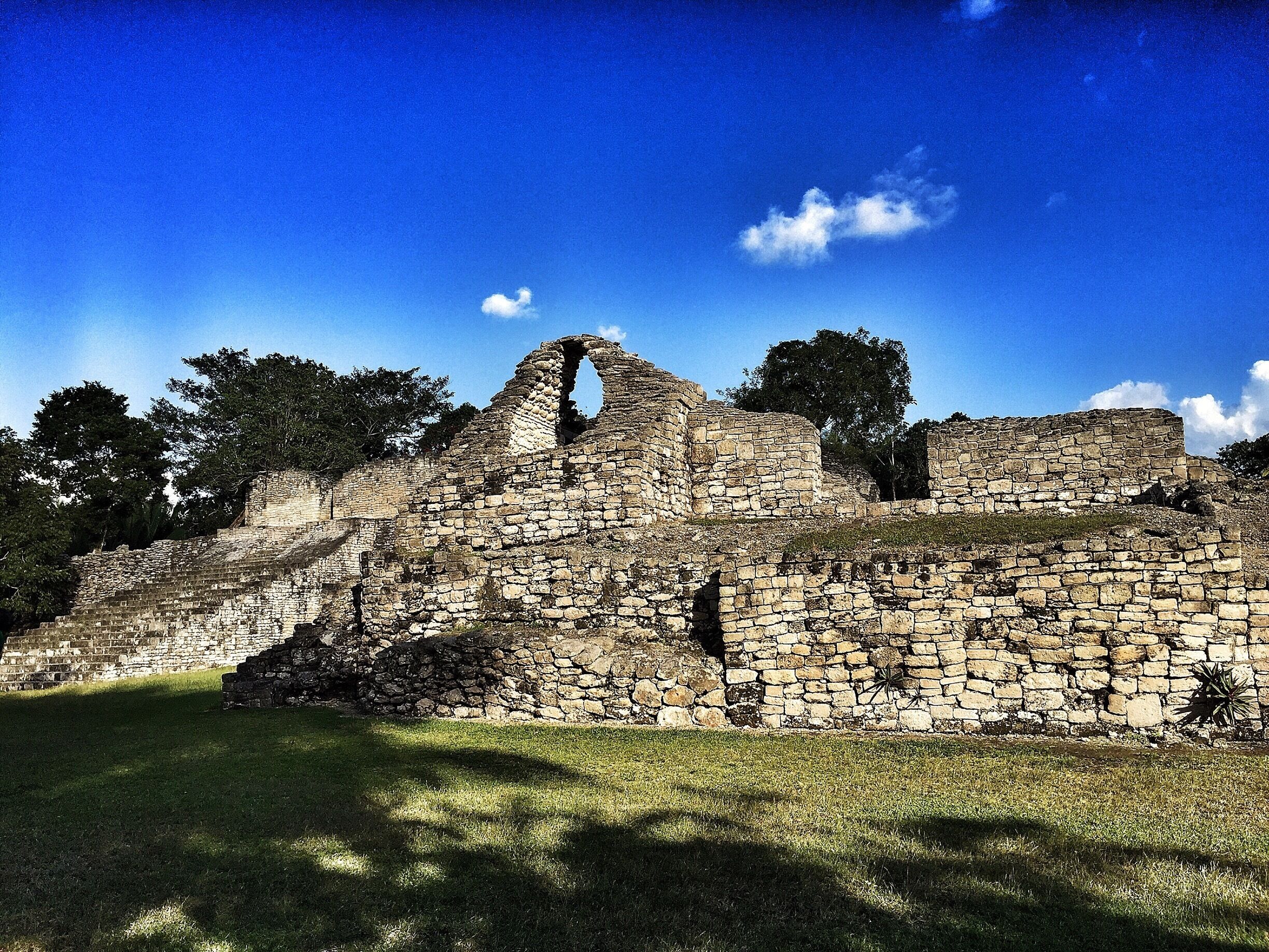 Ruinas de piedra antiguas con una estructura central imponente y muros circundantes.