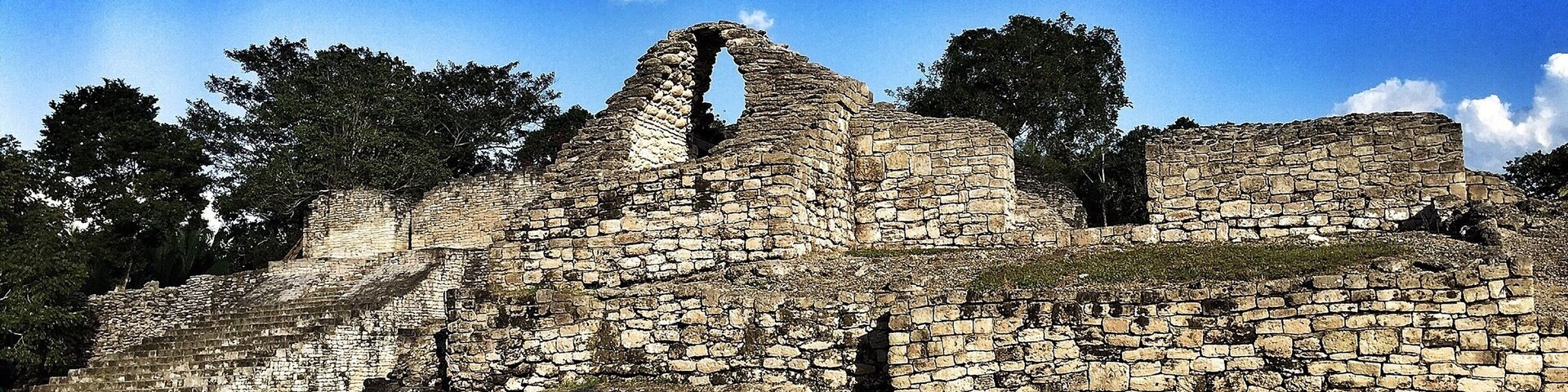 Ruinas de piedra antiguas con una estructura central imponente y muros circundantes.