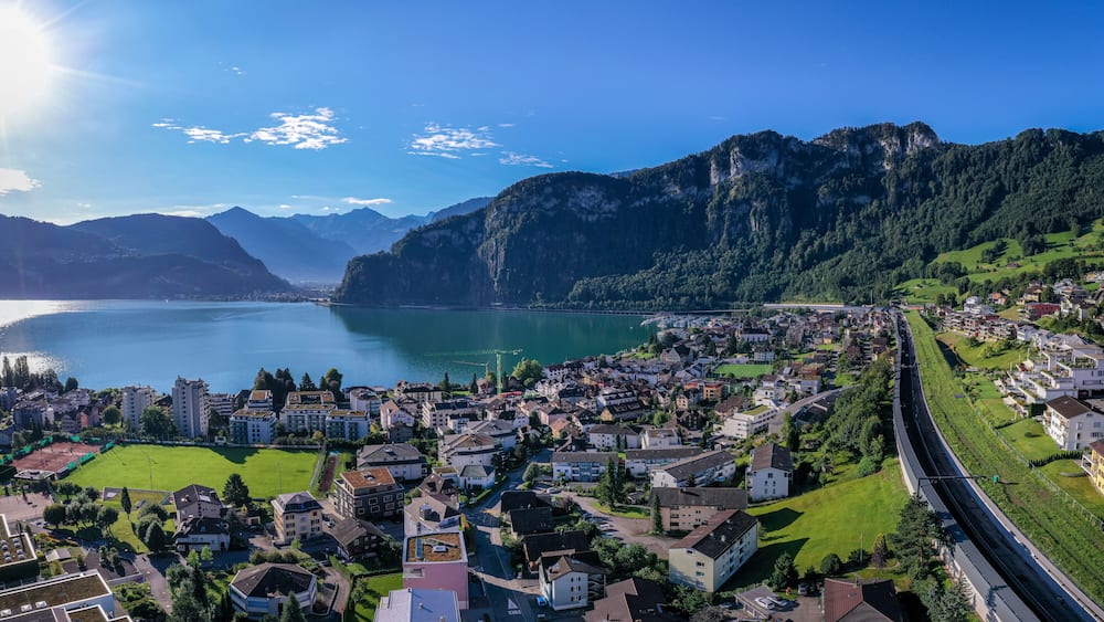 A town by a lake with mountains in the background.