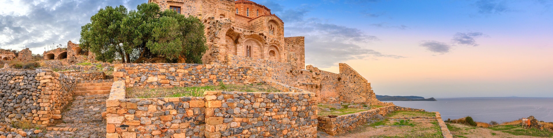 Ancient stone ruins with a view of the sea.