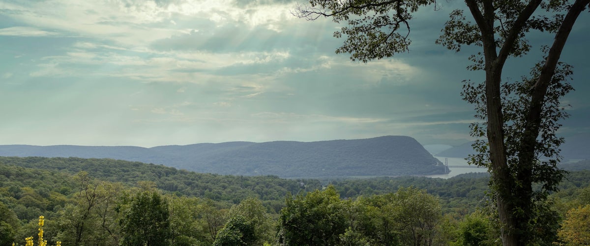 A mountainous landscape with a bridge in the distance.