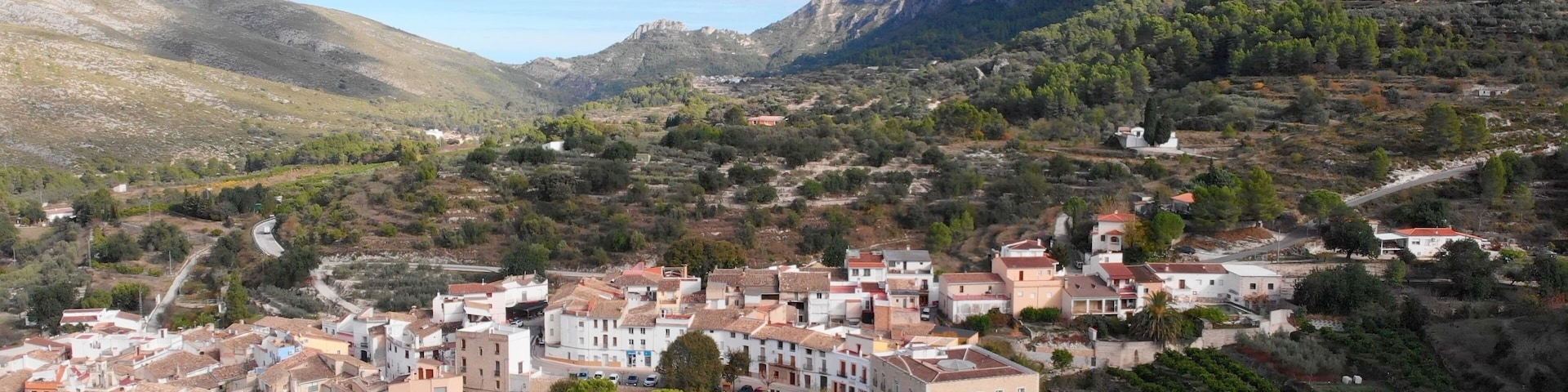 A town nestled in a valley with a mountain backdrop.