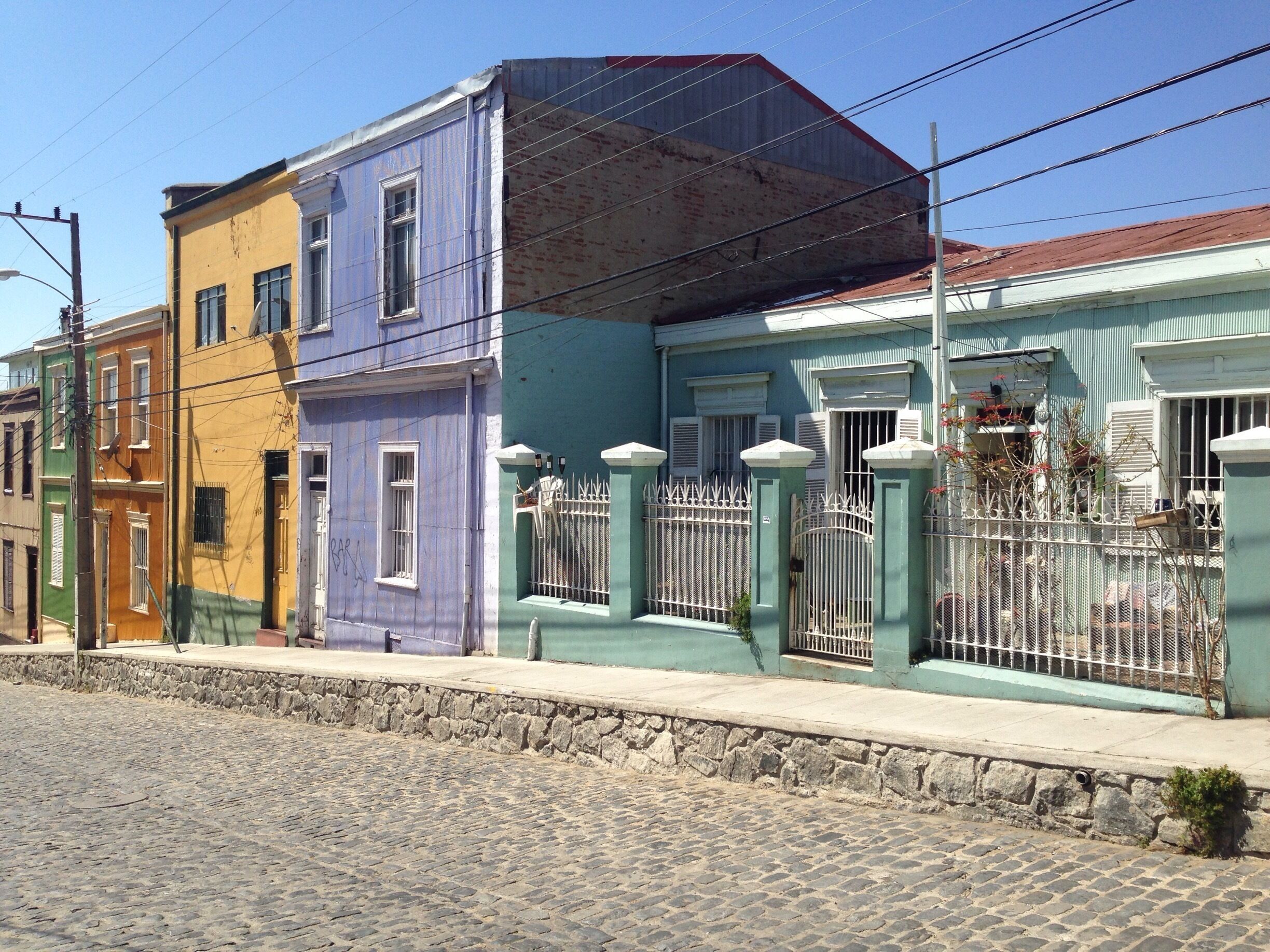 A row of colorful buildings with a cobblestone street.