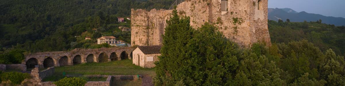 This high-resolution image showcases the historical castle against the stunning landscape. Capture the panoramic beauty of Aghinolfi Castle in Montignoso, Italy, through stunning drone photography.