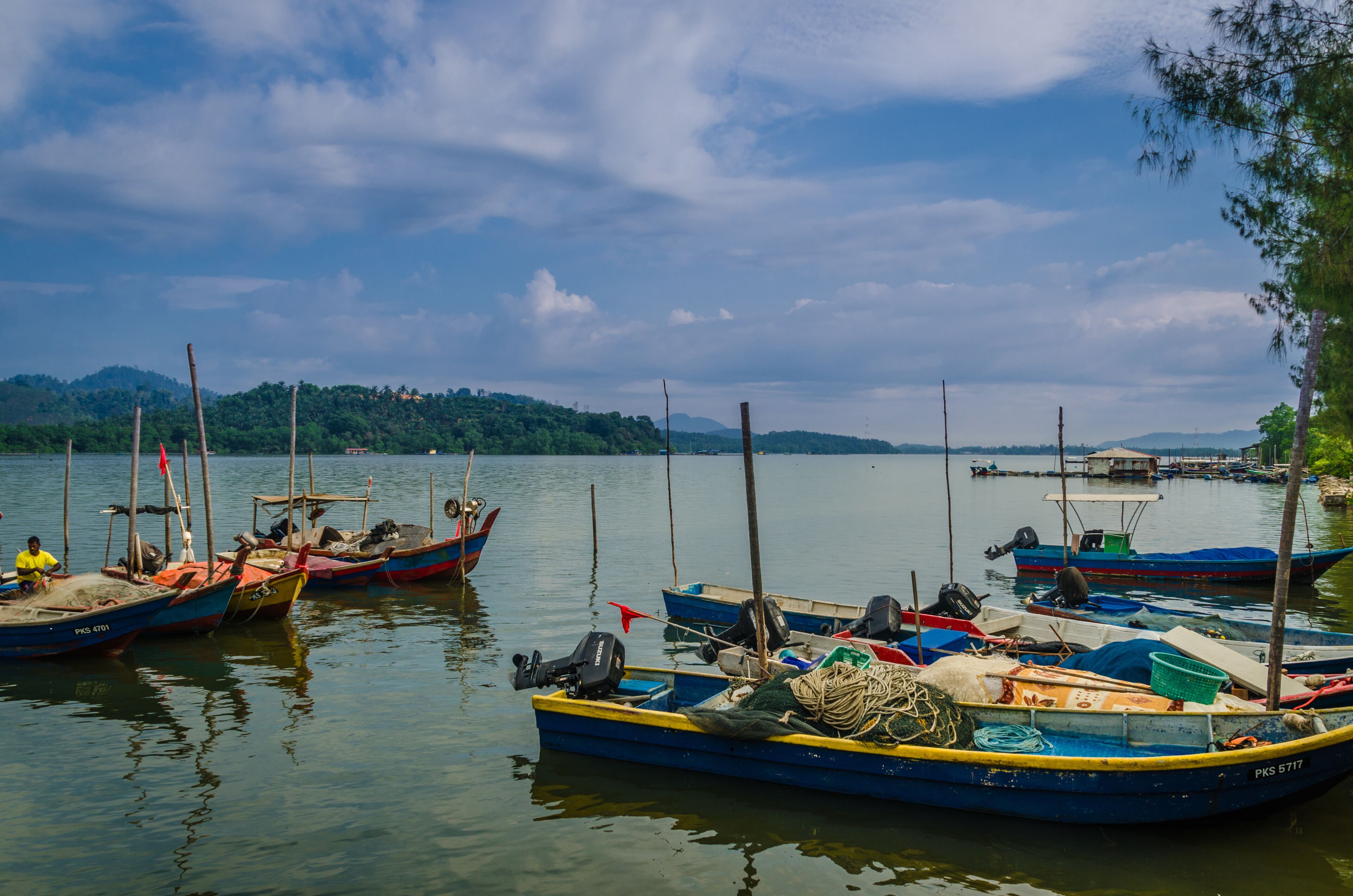 A calm lake with several small boats docked along the shore.