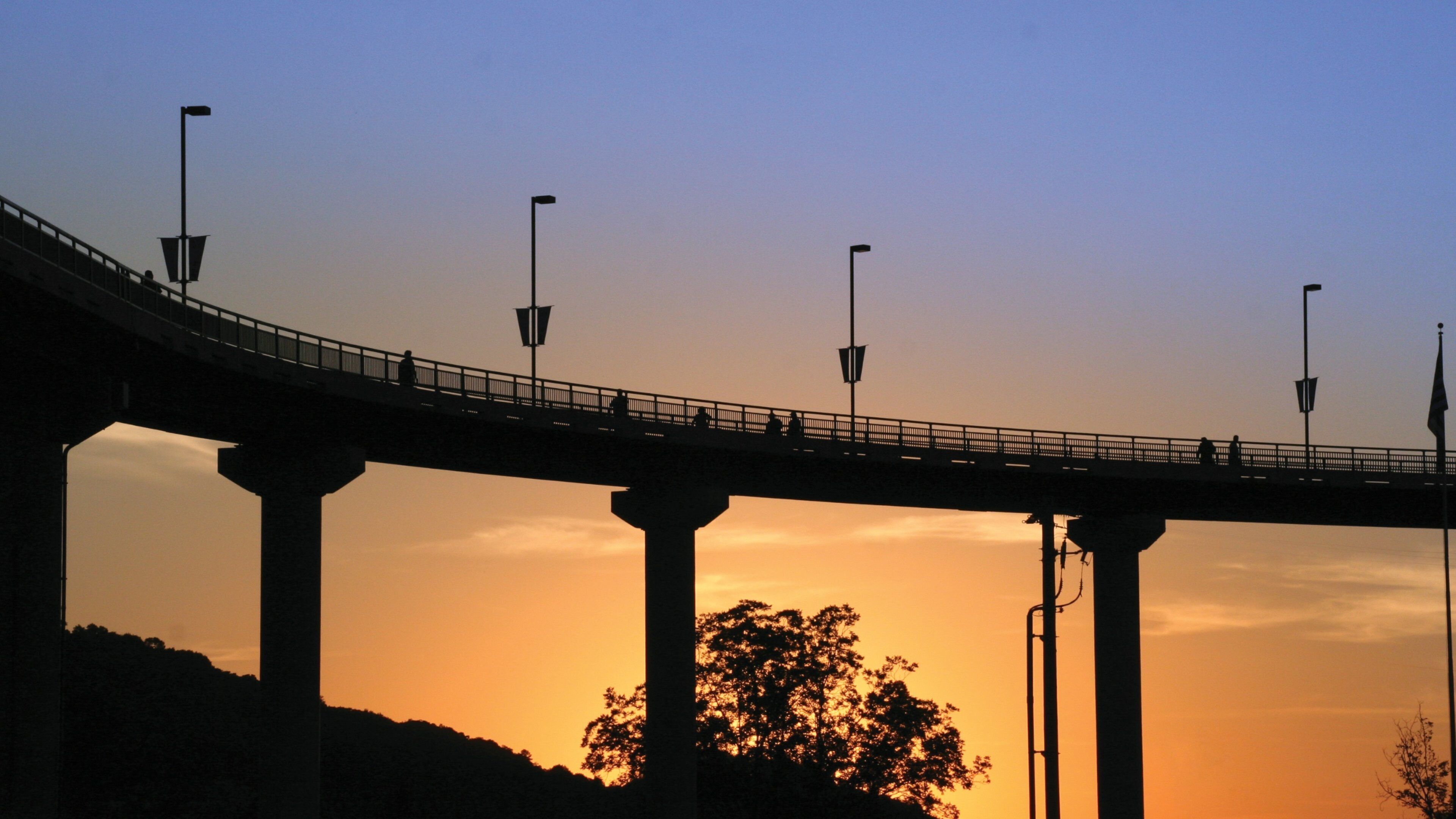 Little Rock featuring a sunset and a bridge
