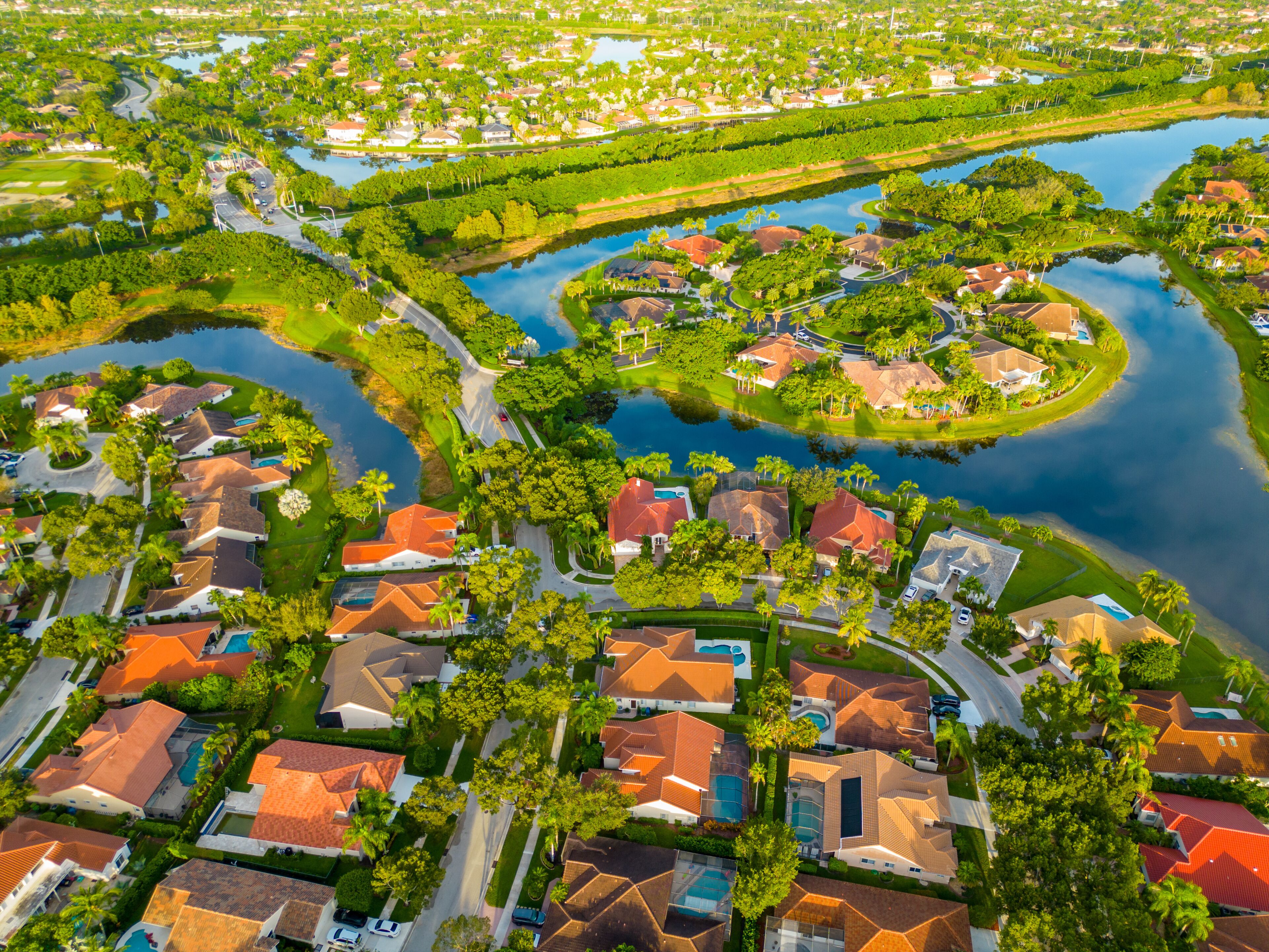 A residential area with houses, roads, and a lake.