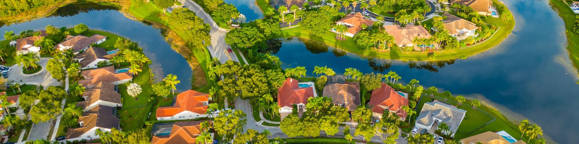 A residential area with houses, roads, and a lake.