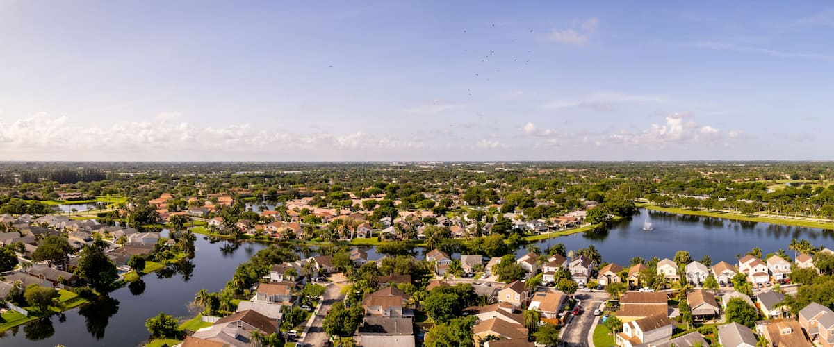 A residential area with a large body of water, surrounded by houses and greenery.