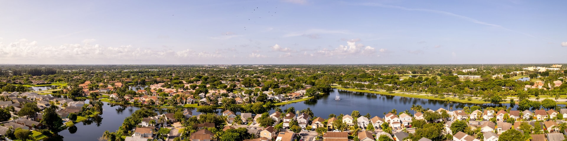 A residential area with a large body of water, surrounded by houses and greenery.