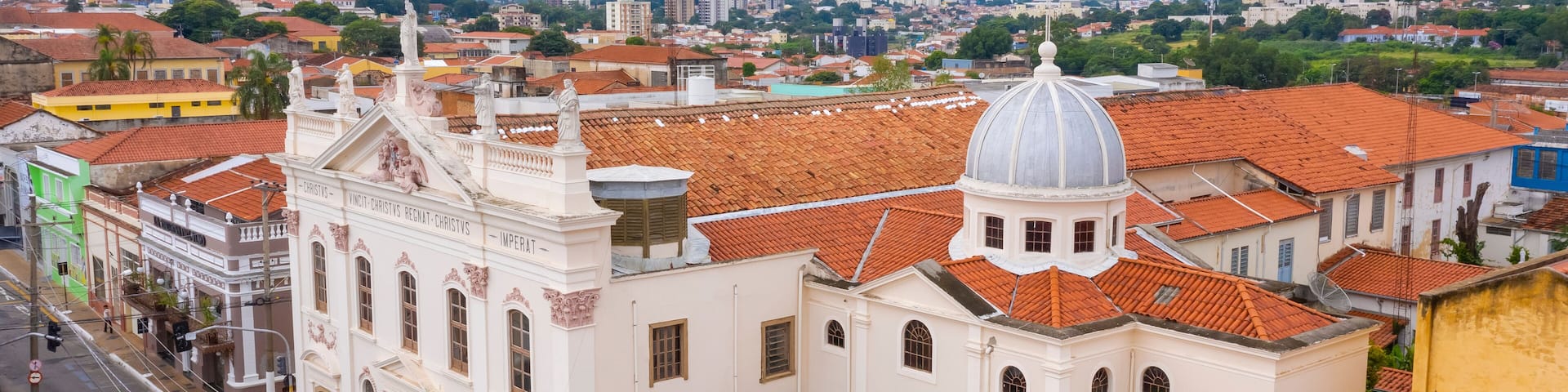 A historic church with a dome and red-tiled roofs in a cityscape.