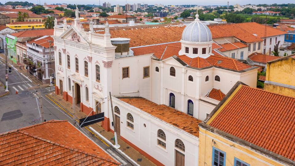 A historic church with a dome and red-tiled roofs in a cityscape.