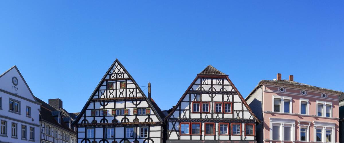 A row of traditional half-timbered houses with a clear blue sky.