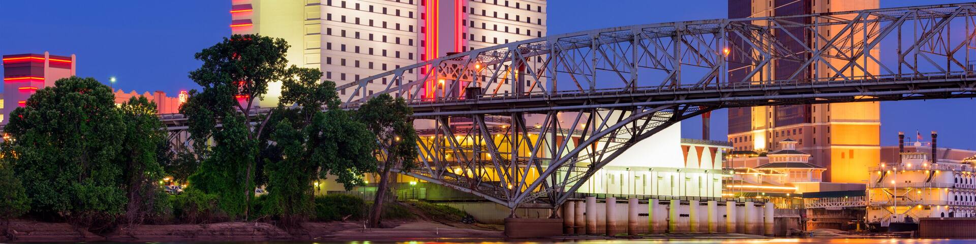 A bridge over a river with reflections of buildings and trees.