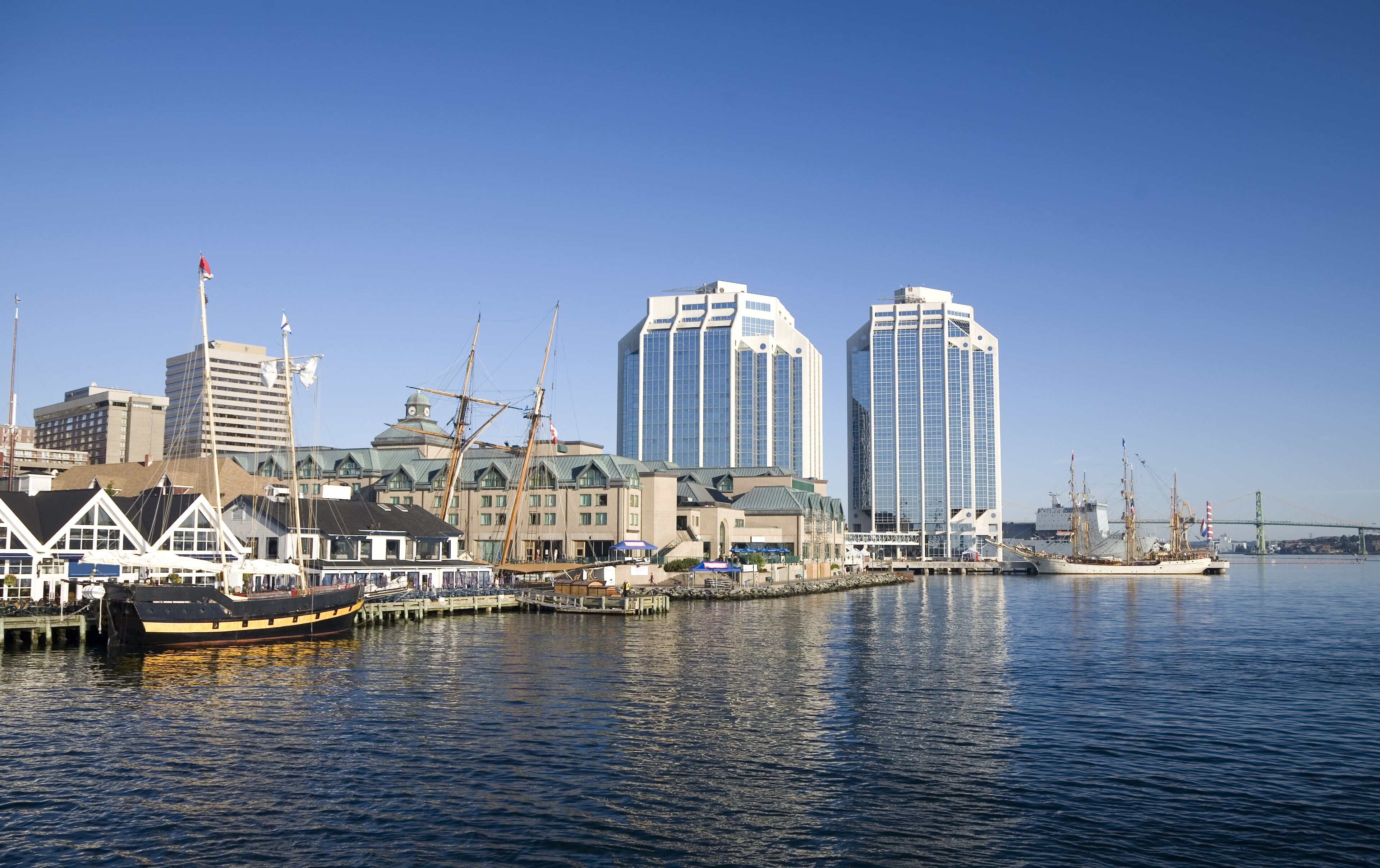 Tall ships docked in the early morning on Halifax's waterfront at Purdy's Wharf and farther down the waterfront during the Nova Scotia Tall Ship Festival 2009. The Angus L. MacDonald Bridge is visible