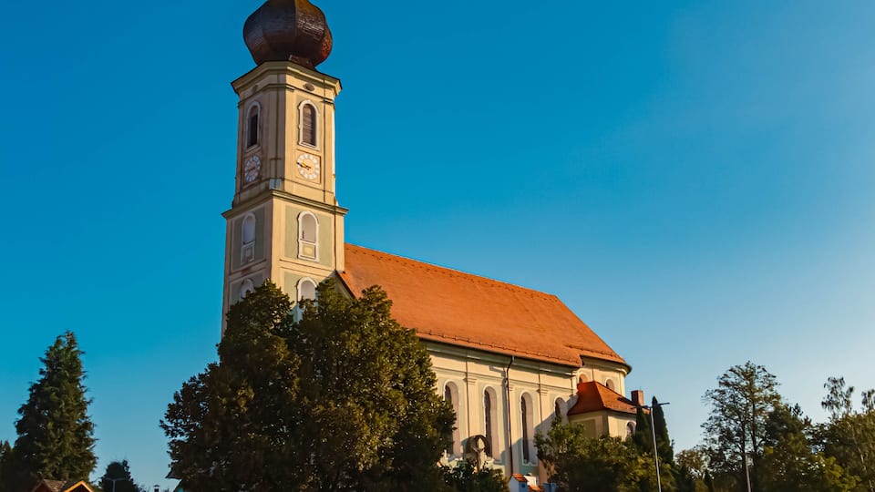 A church with a tall bell tower and a red roof.