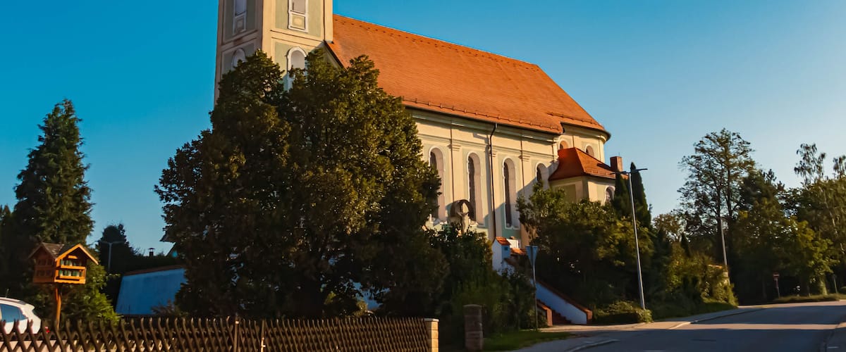 A church with a tall bell tower and a red roof.