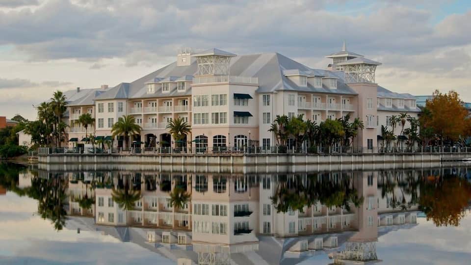 A large, multi-story building with a reflective water surface in front.