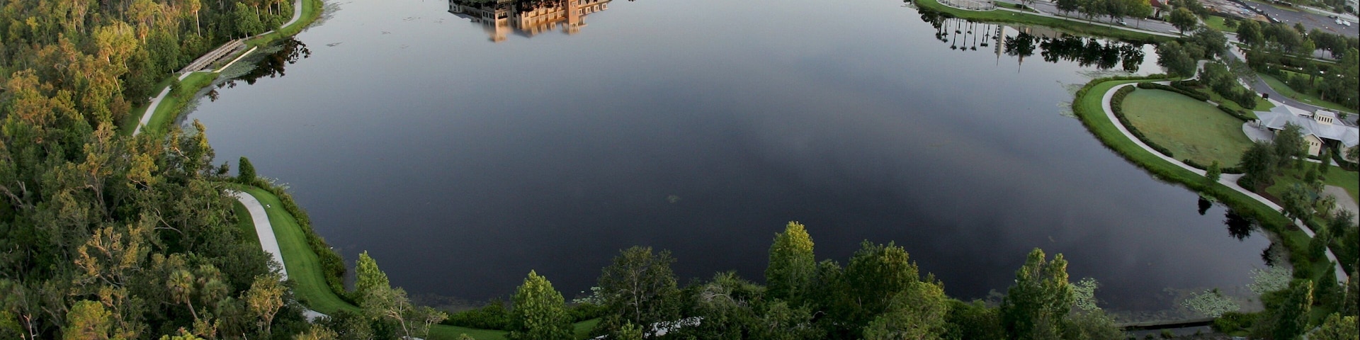 A large lake surrounded by dense forest and a mix of residential and commercial buildings.
