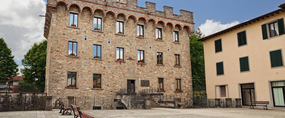 A historic stone building with arched windows and a tower.