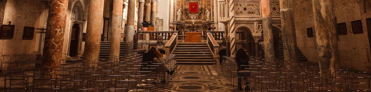 An ornate church interior with high ceilings, arched columns, and a central altar.