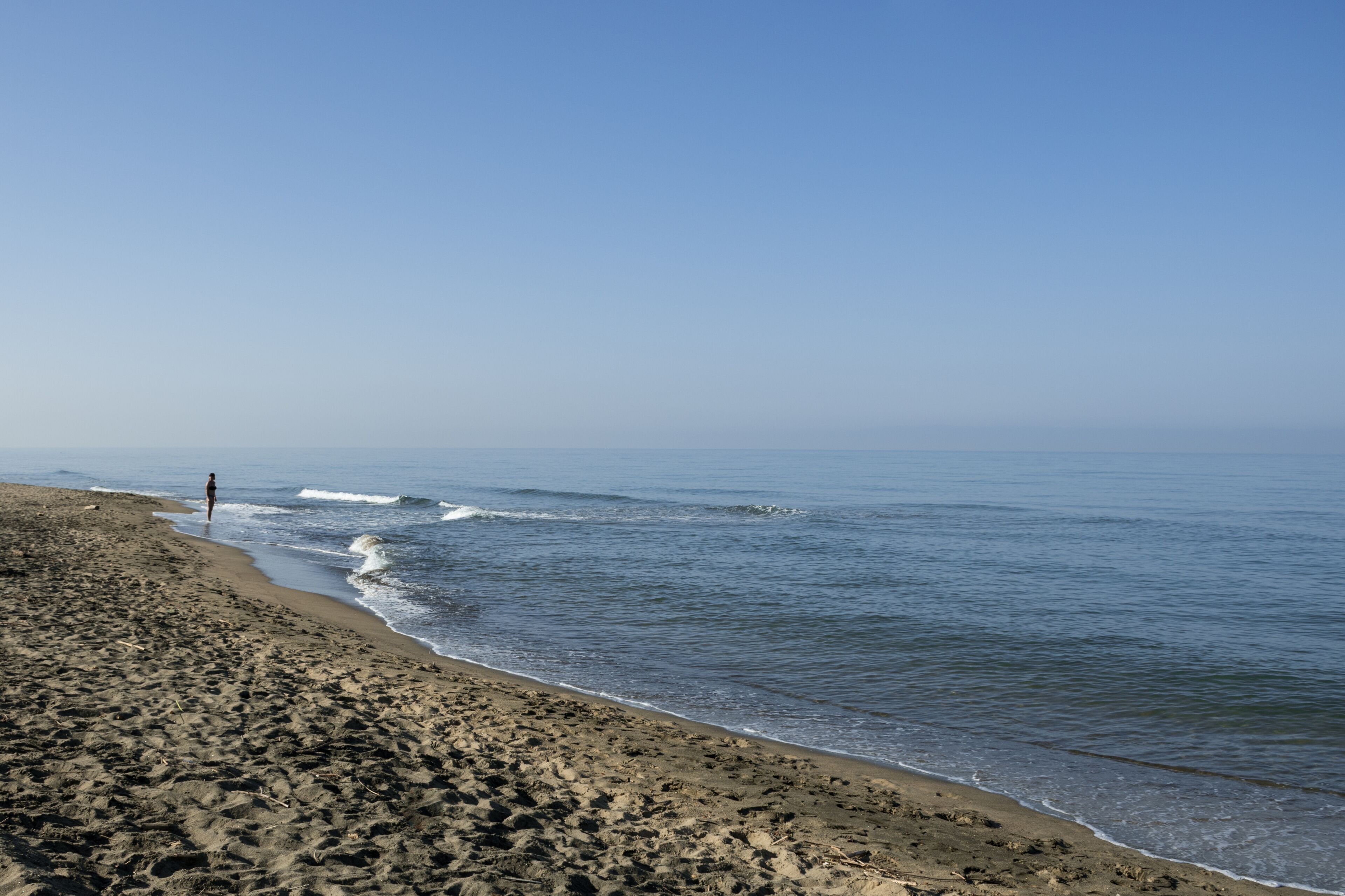 Waves and black sand of volcanic origin. Seascape of Baia Domizia, Province of Caserta, Italy