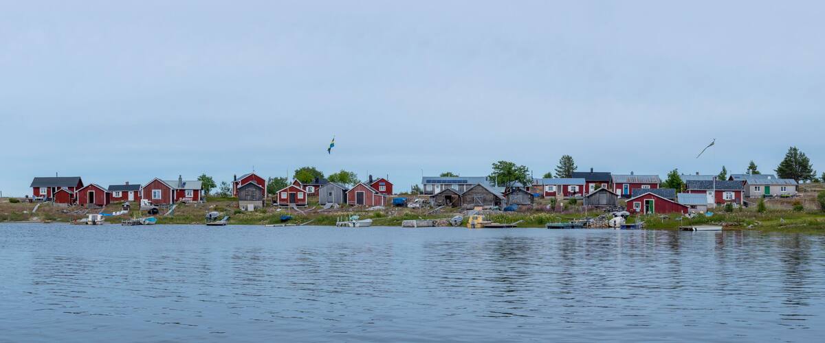 A lakeside village with red houses and boats.