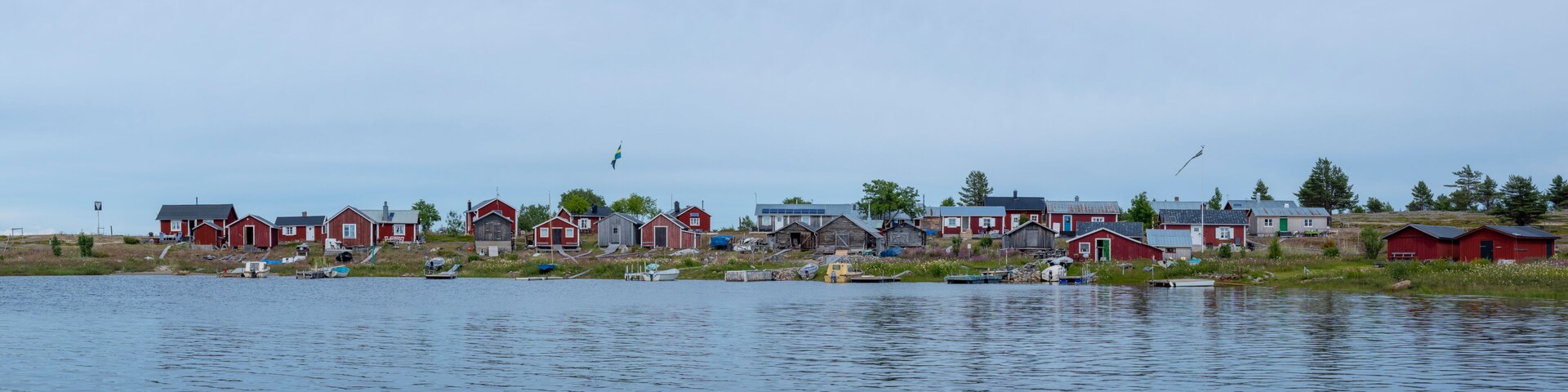 A lakeside village with red houses and boats.