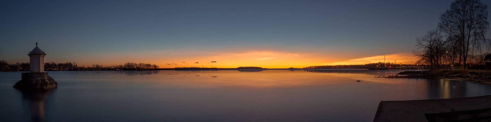 panorama with a little lighthouse in a lake during sunset