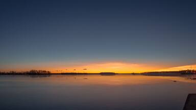 panorama with a little lighthouse in a lake during sunset