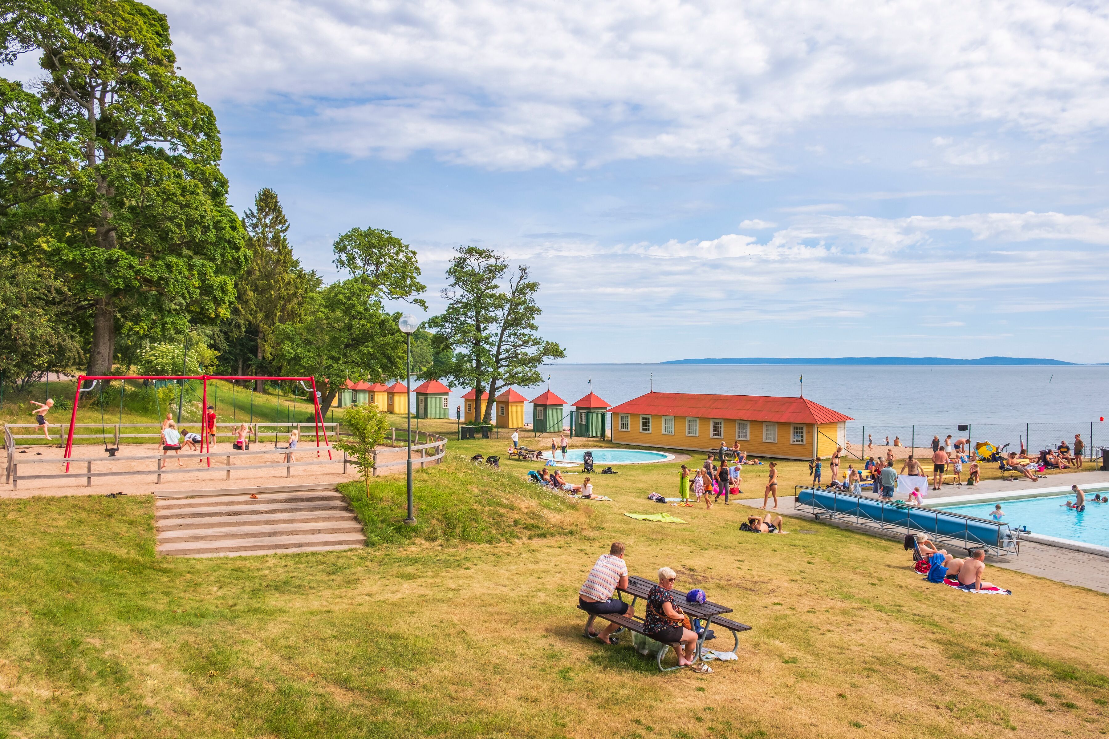 Bathing place with playing children at a playground