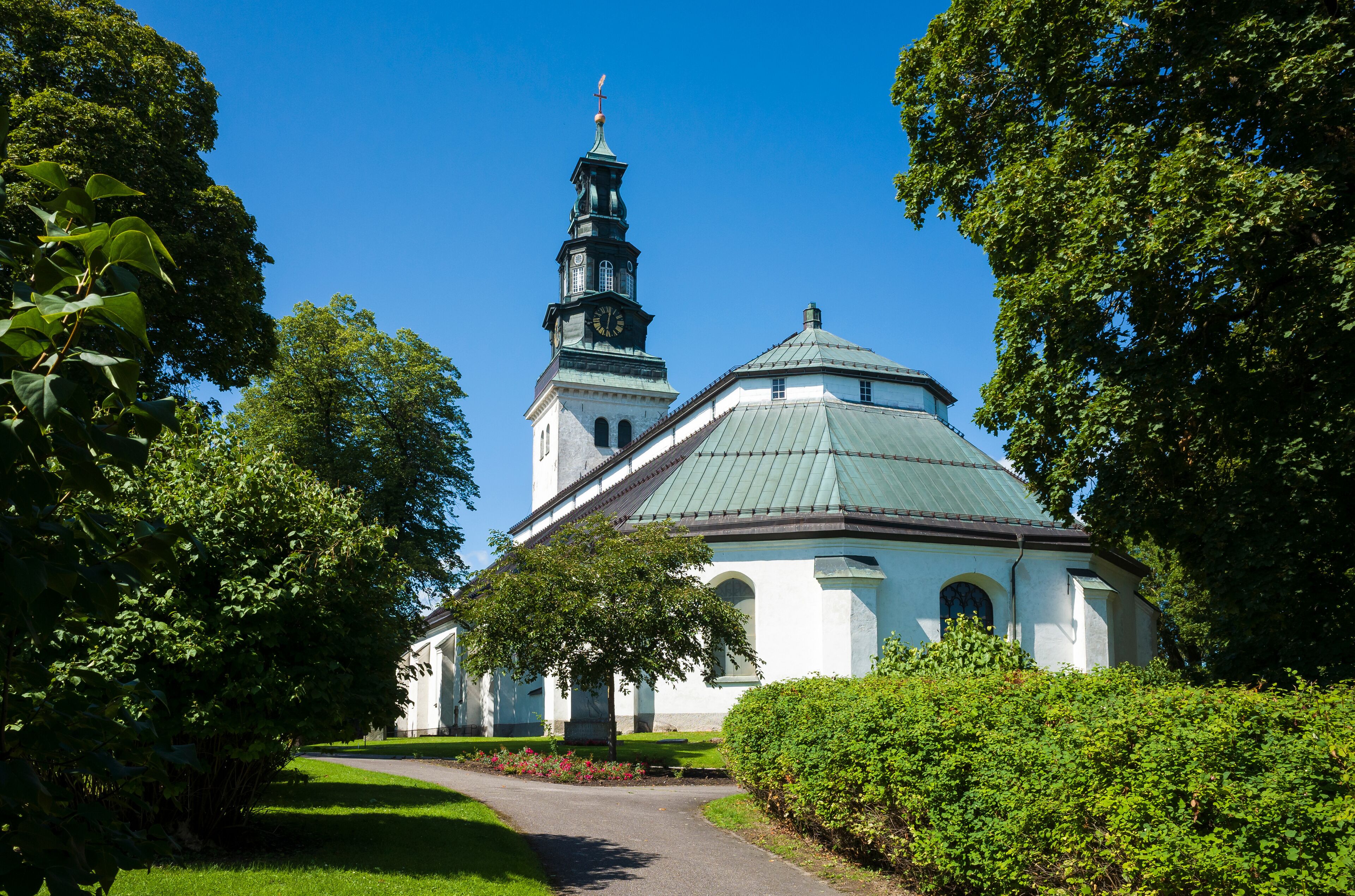 A church with a green roof and a clock tower.