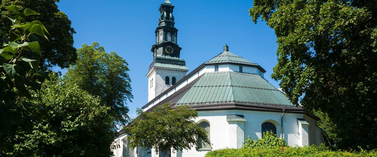 A church with a green roof and a clock tower.