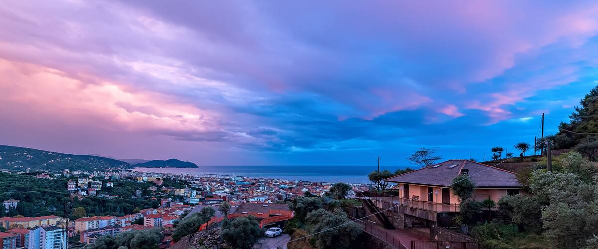 A coastal town with a view of the sea and mountains in the background.