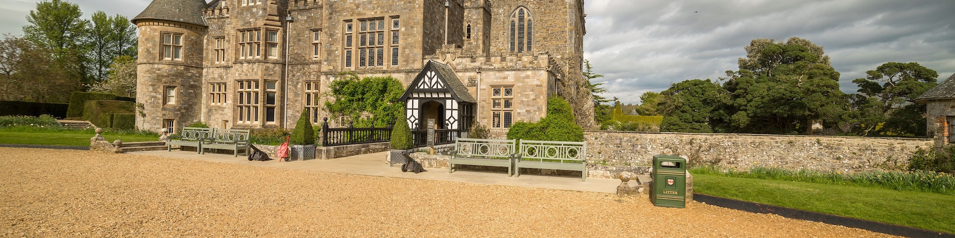 A large stone building with a traditional architectural style, featuring multiple chimneys and a prominent entrance with a small porch.