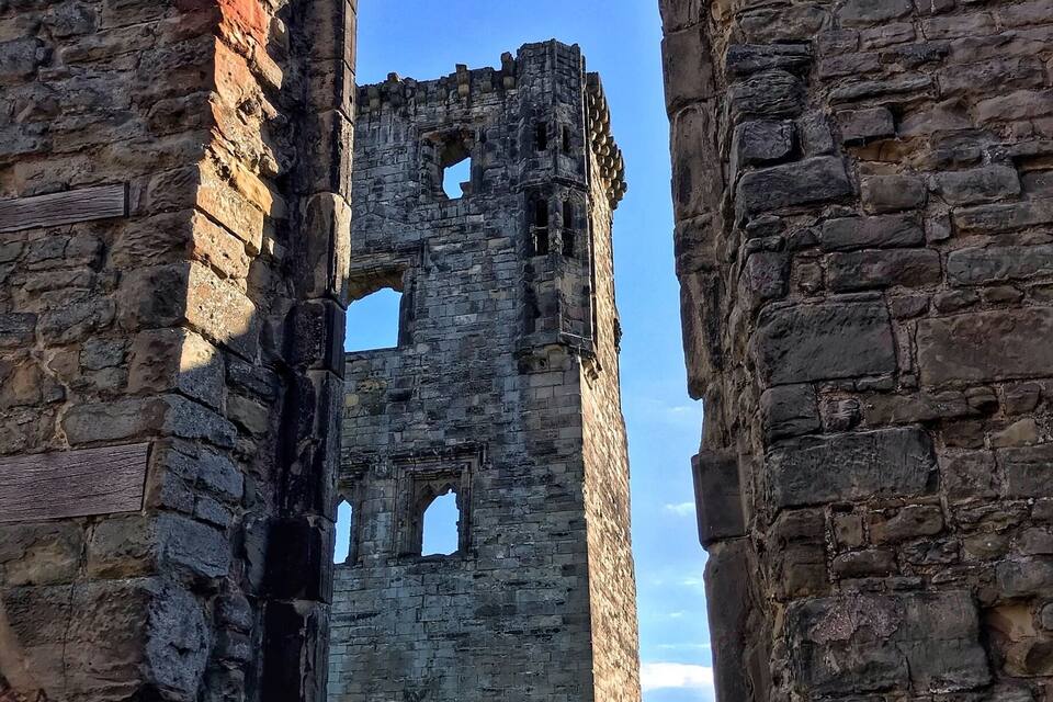 An ancient stone archway leading into a ruined tower.