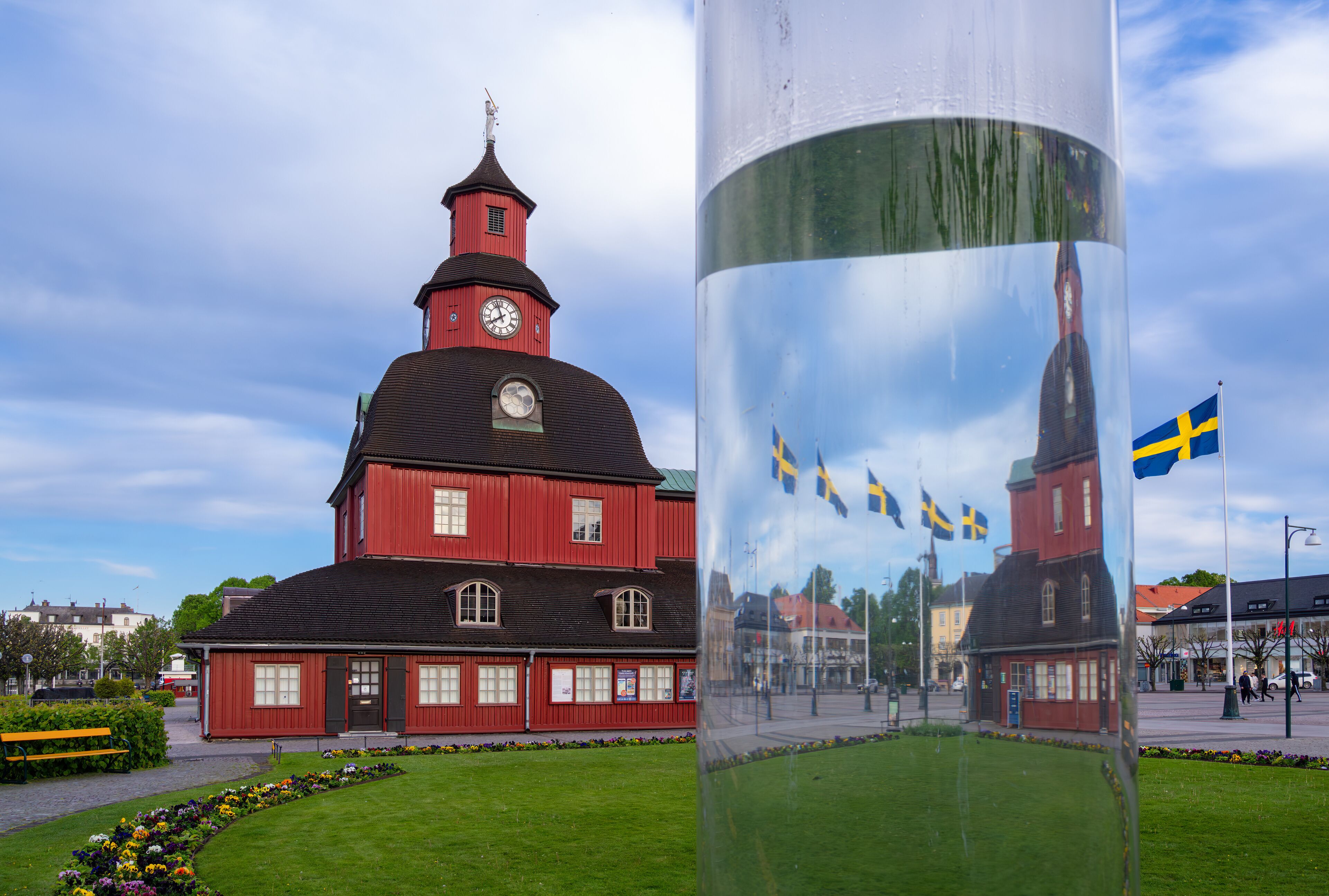 Lidkoping, Sweden - May 28, 2023: Historical red wooden town hall with waving swedish flags in Lidkoping.