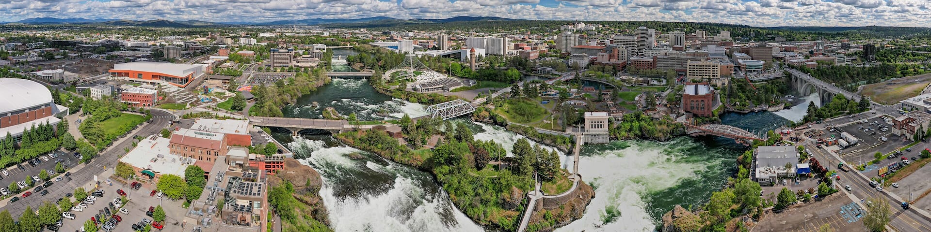 A cityscape with a river, bridges, and surrounding greenery.