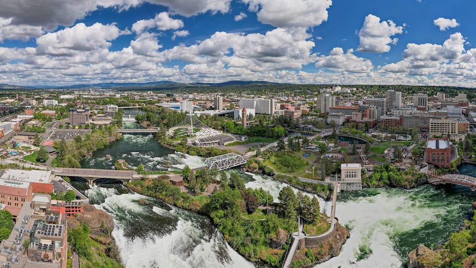 A cityscape with a river, bridges, and surrounding greenery.