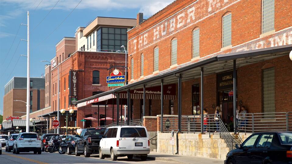 A street lined with vintage buildings, including a brick building with 'The Hub' sign and a white van parked on the side.