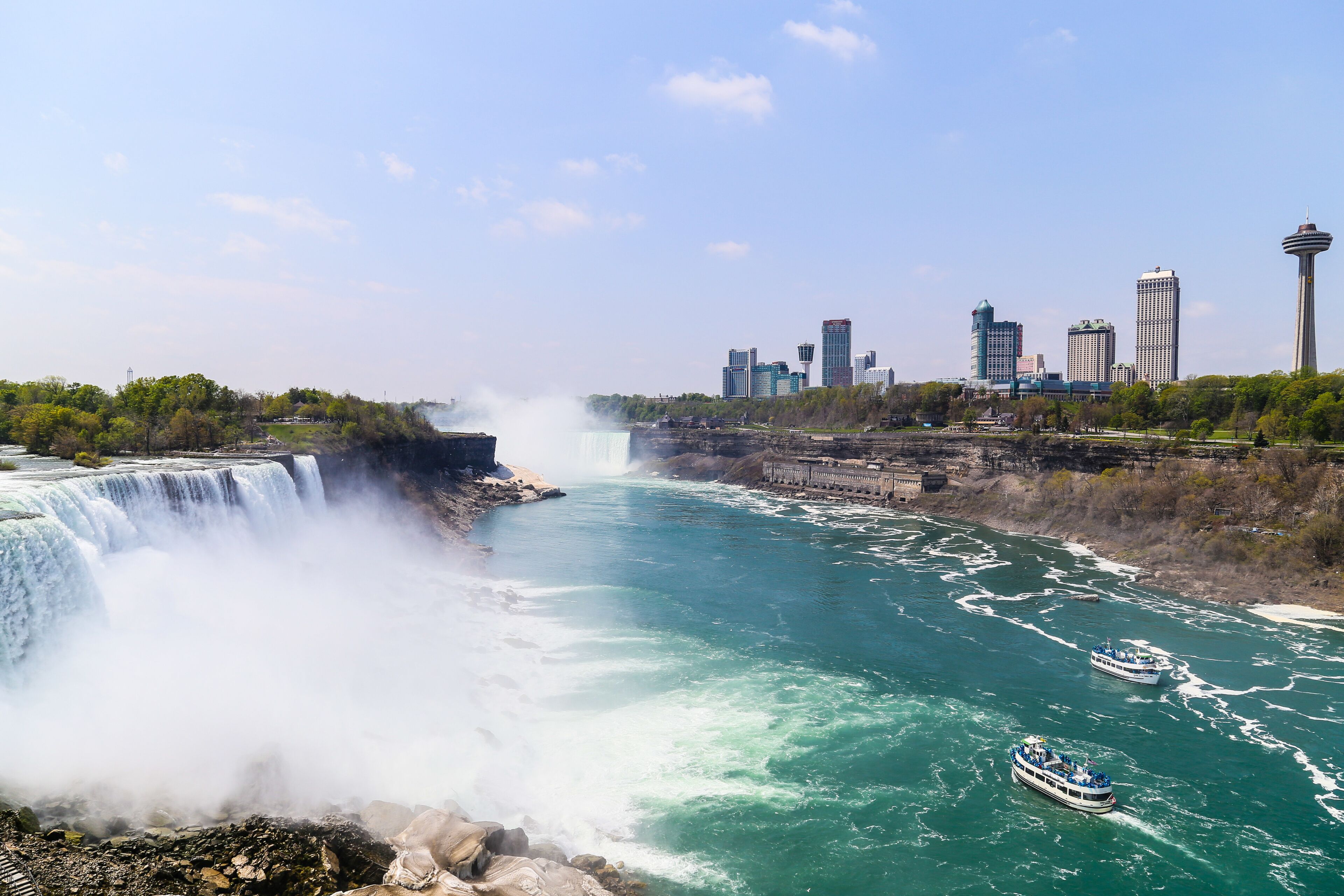 A large waterfall, a river, a city skyline, and a tower.