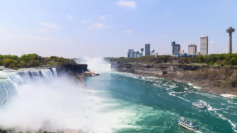 A large waterfall, a river, a city skyline, and a tower.