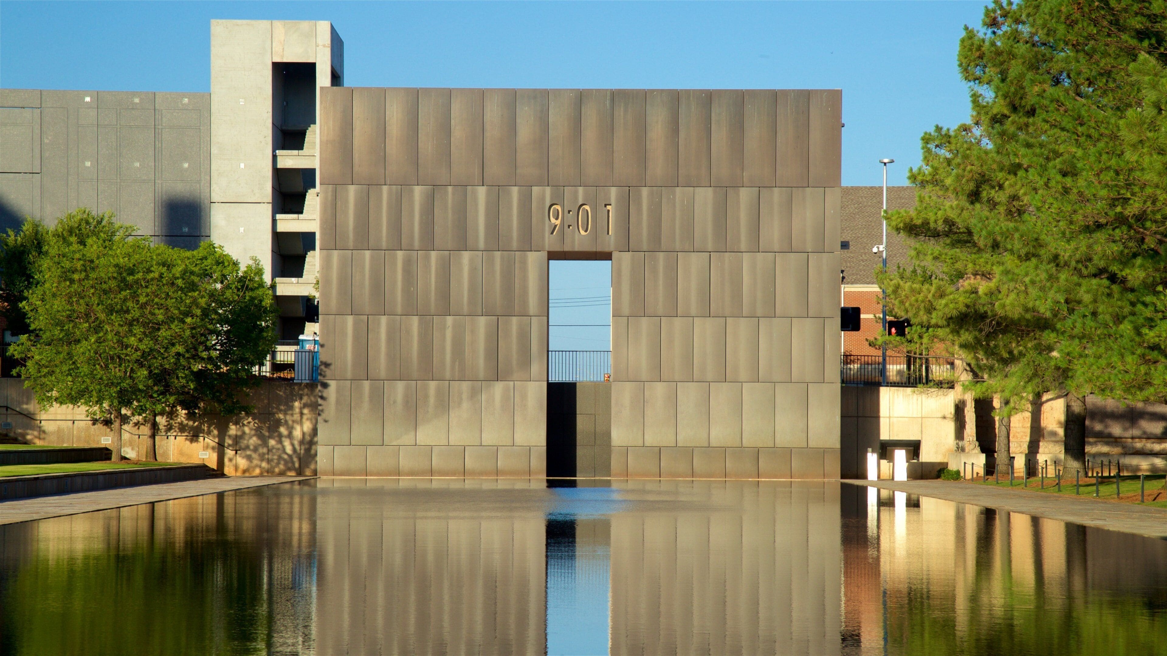 A modern building with a reflective water pool in front.