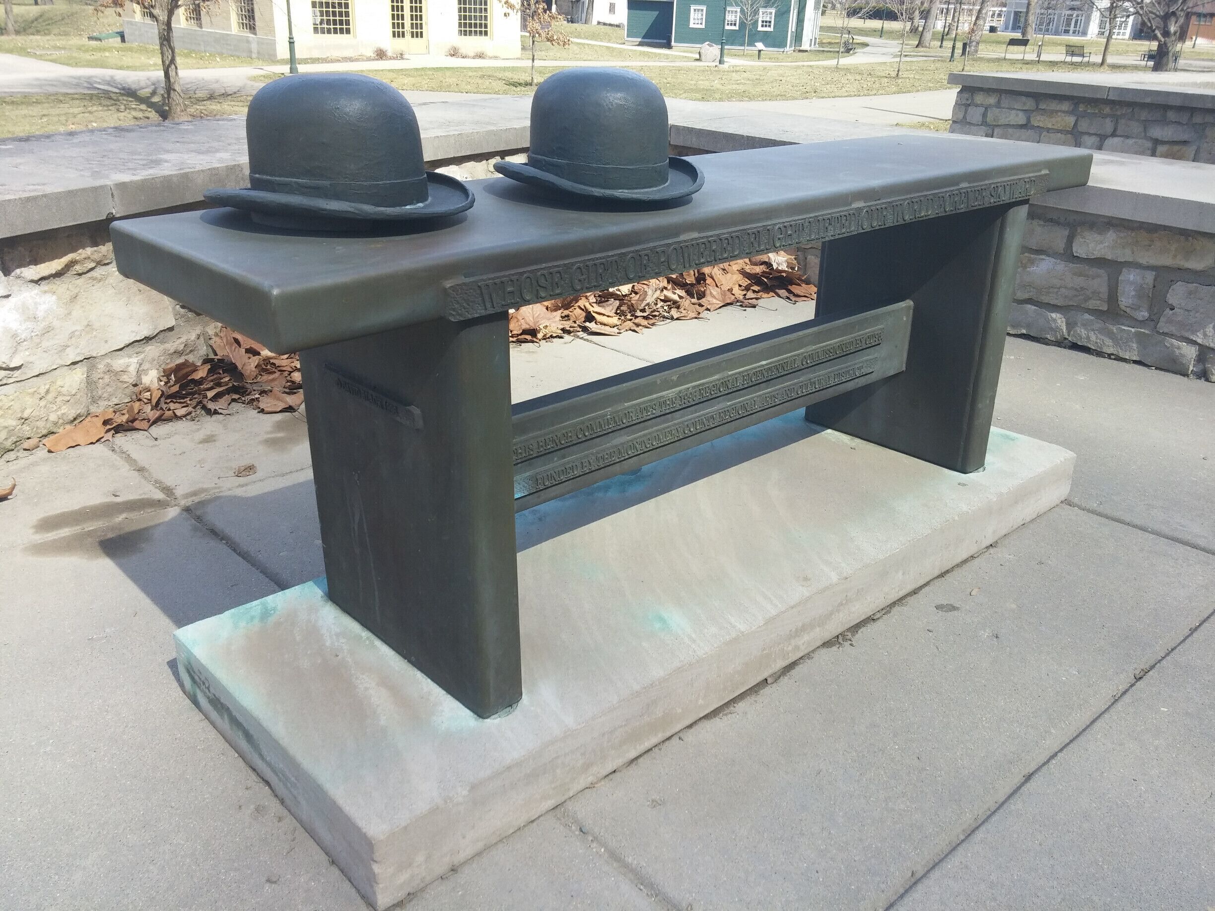 "Whose gift of powered flight lifted our world forever skyward."

A bronze bench tribute to the Wright Brothers.