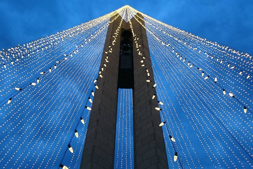 Ein hohes Gebäude mit blauer Fassade und zahlreichen Lichtern.