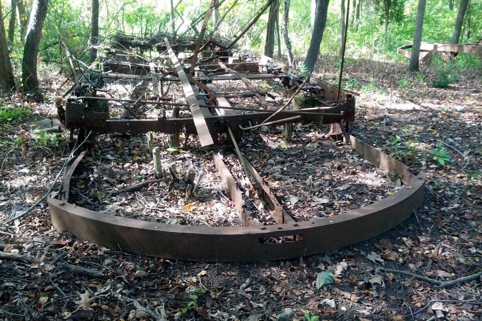 A rusted metal structure in a forest.